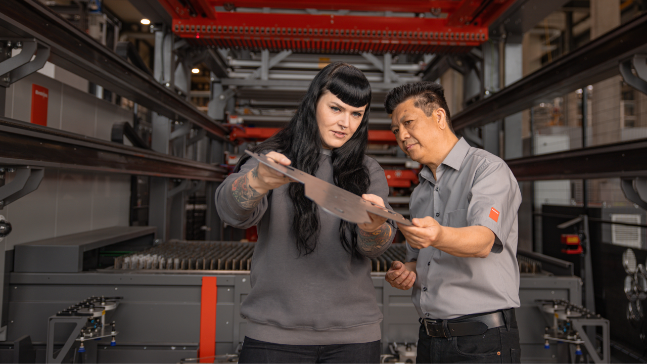Bystronic employees reviewing a cut sheet metal part 