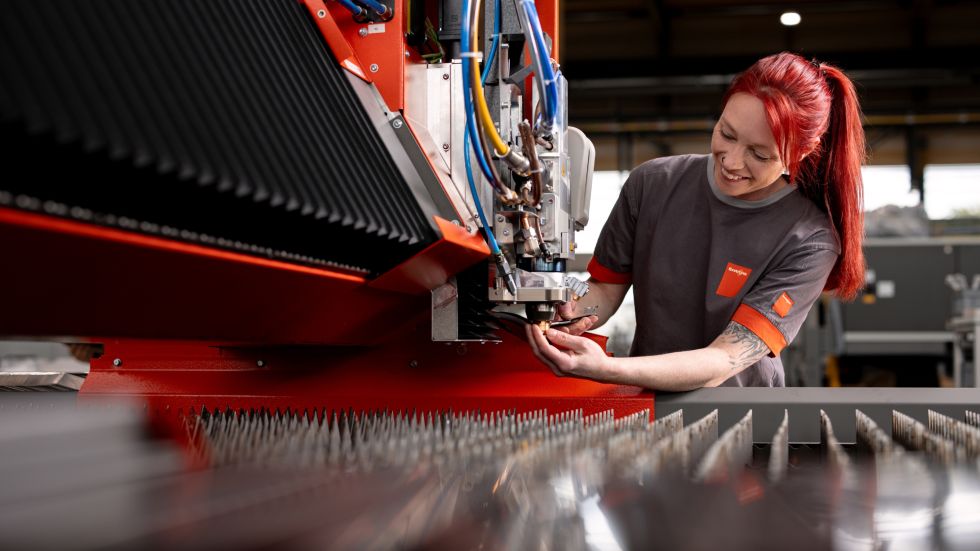 Woman with red hair provides after sales and service, repairing a machine.