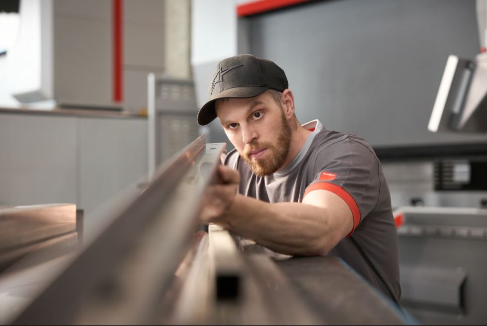 Employee checks metal part